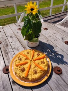 Kakku ja kukat kesäpäivän auringossa.